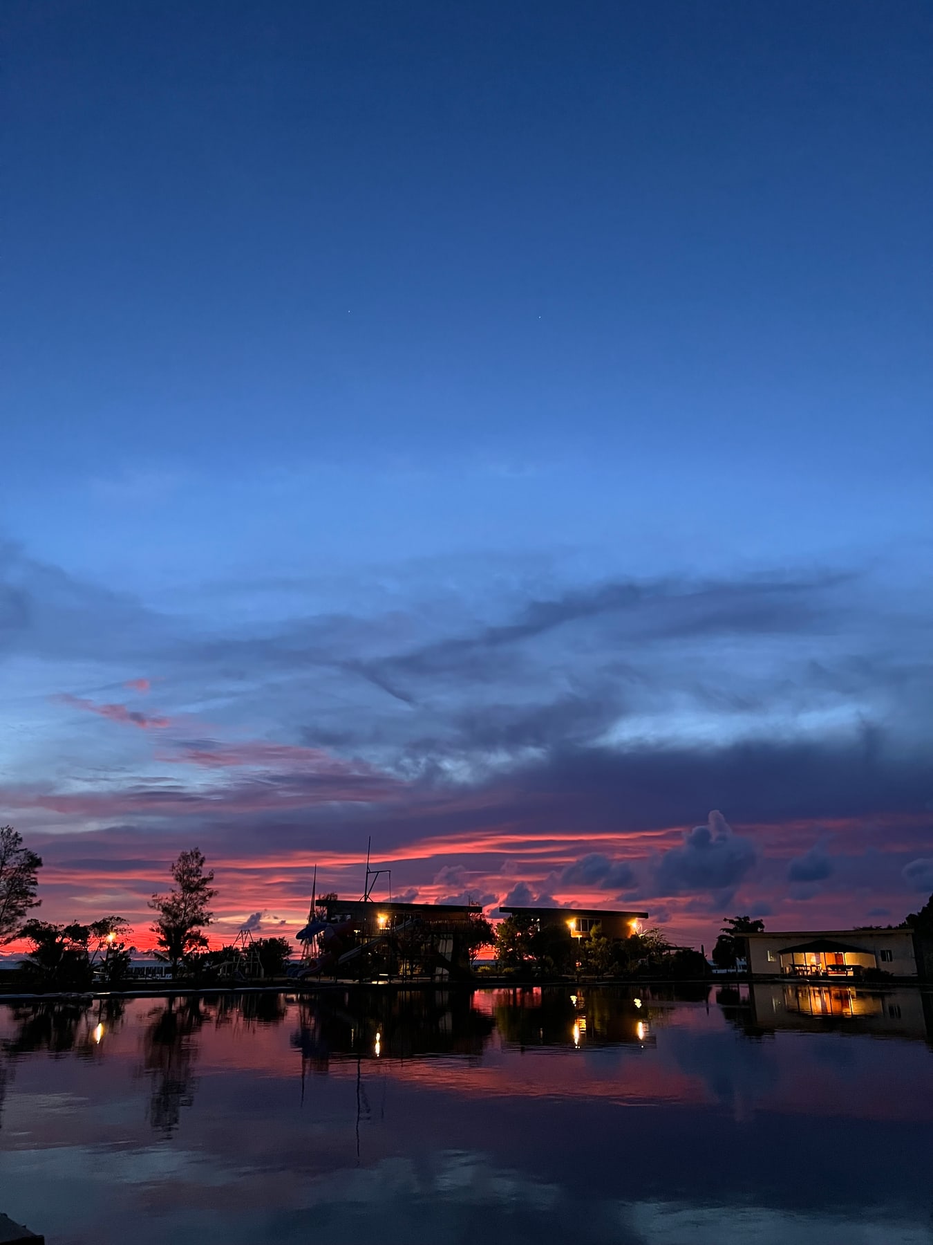 แสงสีแดงยามพลบค่ำสะท้อนบนผิวน้ำหน้าบ้านพัก Aloha Sunset